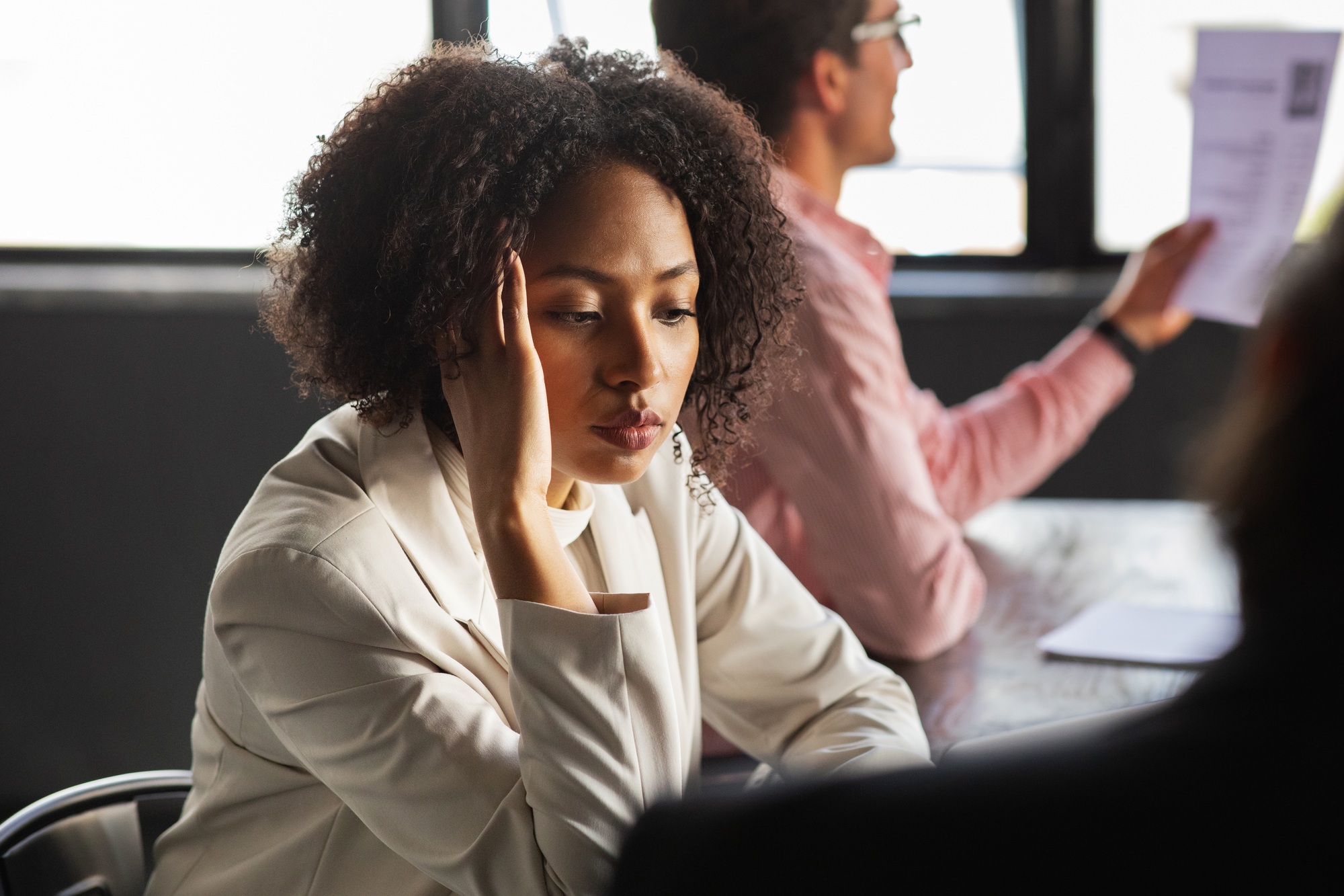Stressed overwhelmed african businesswoman feels tired at corporate meeting